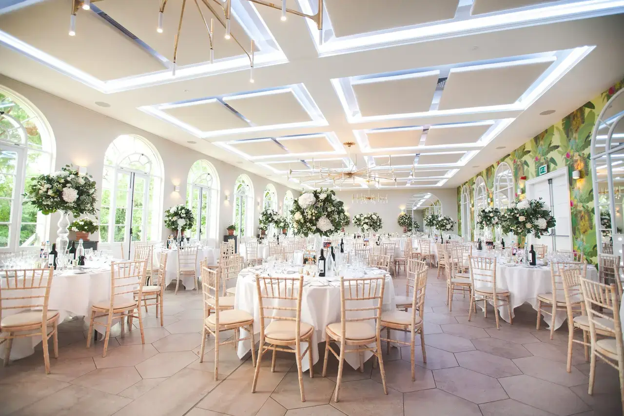 Elegant event dining room with white table linen and floral centrepieces
